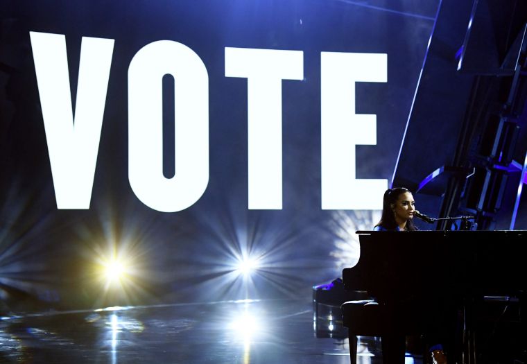 Demi Lovato with Vote message behind her