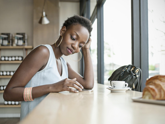 Young woman in cafÃ© with mobile phone